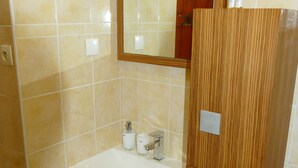 Une salle de bain avec un meuble-lavabo en bois, un miroir et un lavabo.