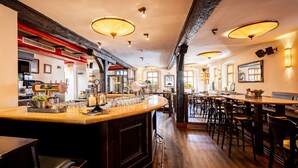 A spacious bar area with a long counter, multiple stools, and a variety of bar tools and glasses. - Watzdorfer Geleitschenke und Herberge (Weimar)