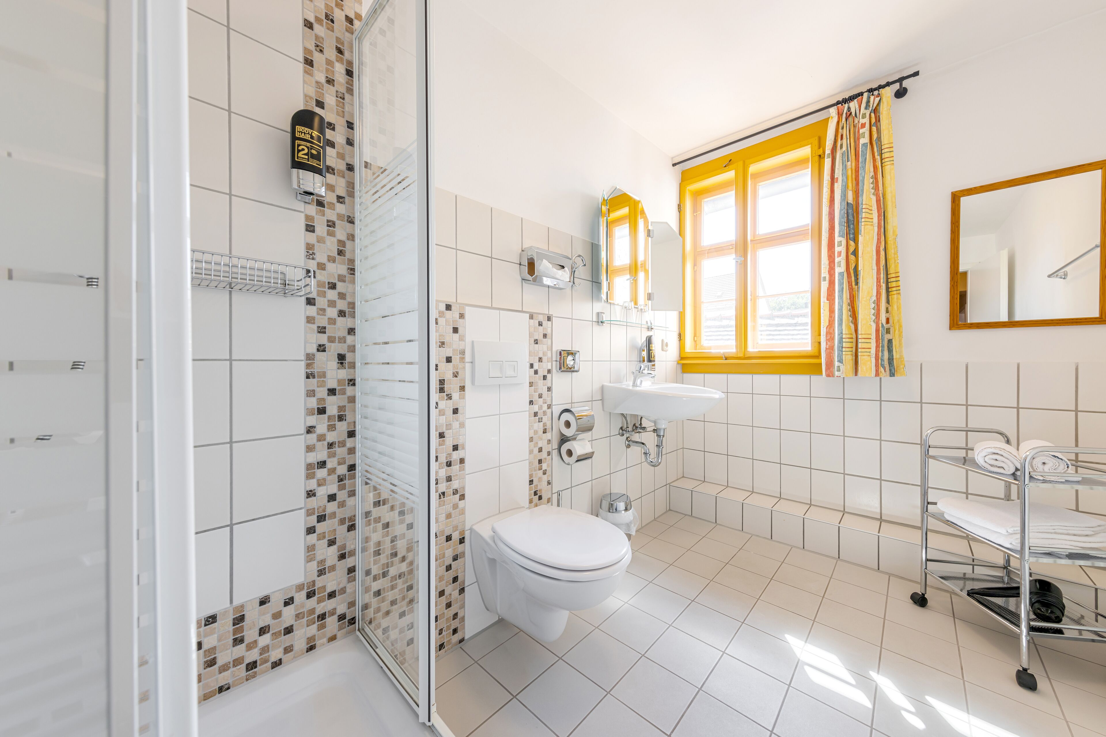 A modern bathroom with a toilet, sink, and shower area.