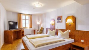 A hotel room with a wooden bed, a desk, a chair, a TV, and two wall-mounted lamps. - Watzdorfer Geleitschenke und Herberge (Weimar)