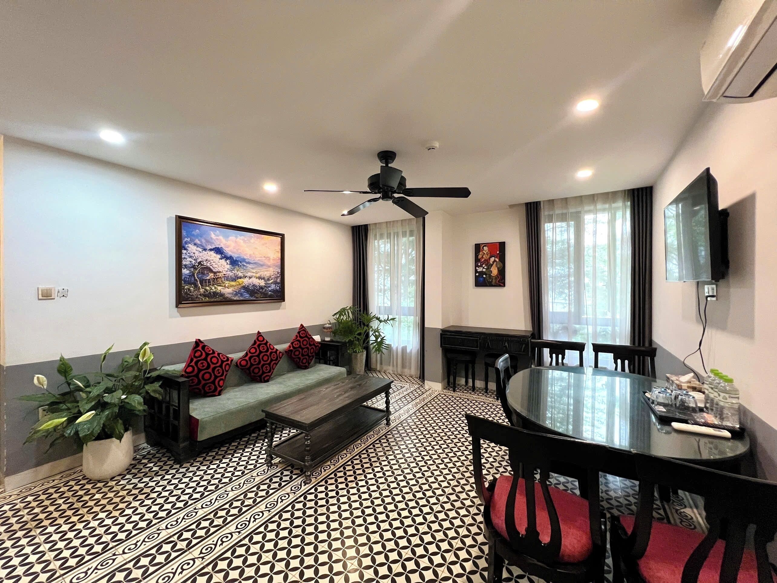 Uma sala de estar moderna com sofá, mesa de centro, mesa de jantar, cadeiras e obras de arte nas paredes.