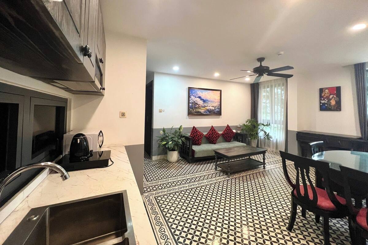 A modern living room with a sofa, coffee table, and dining area.