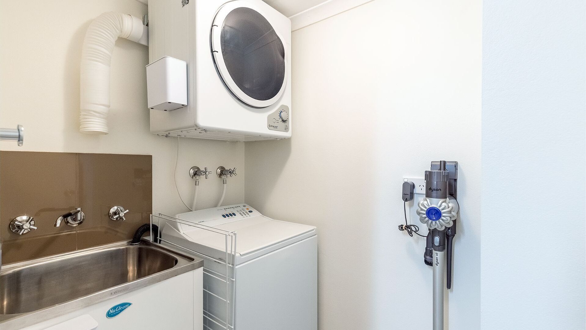 Een klinische omgeving met een wastafel, een wasmachine en medische apparatuur.