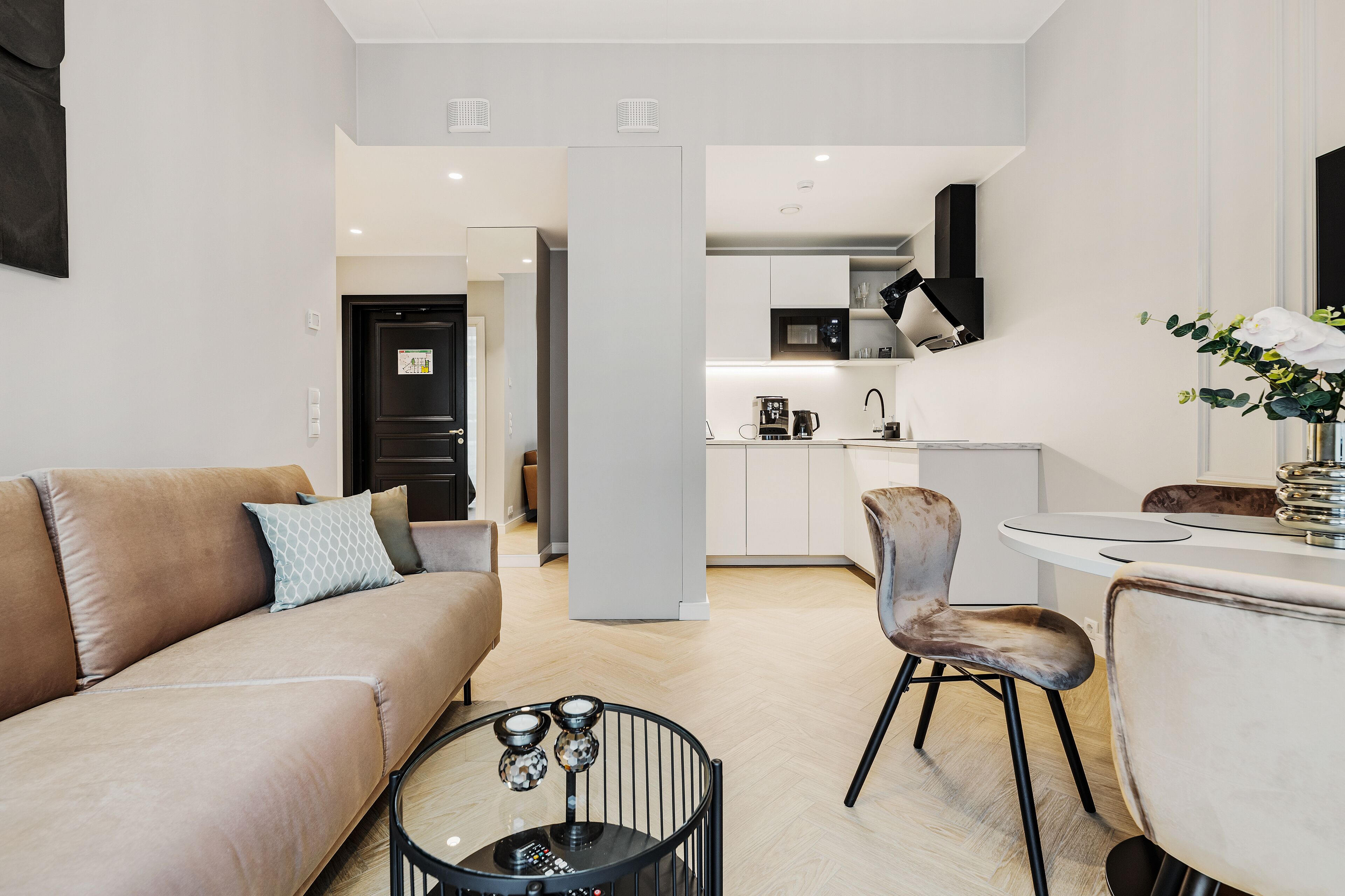 A modern living room with a sofa, a coffee table, and a dining area with a chair and table.