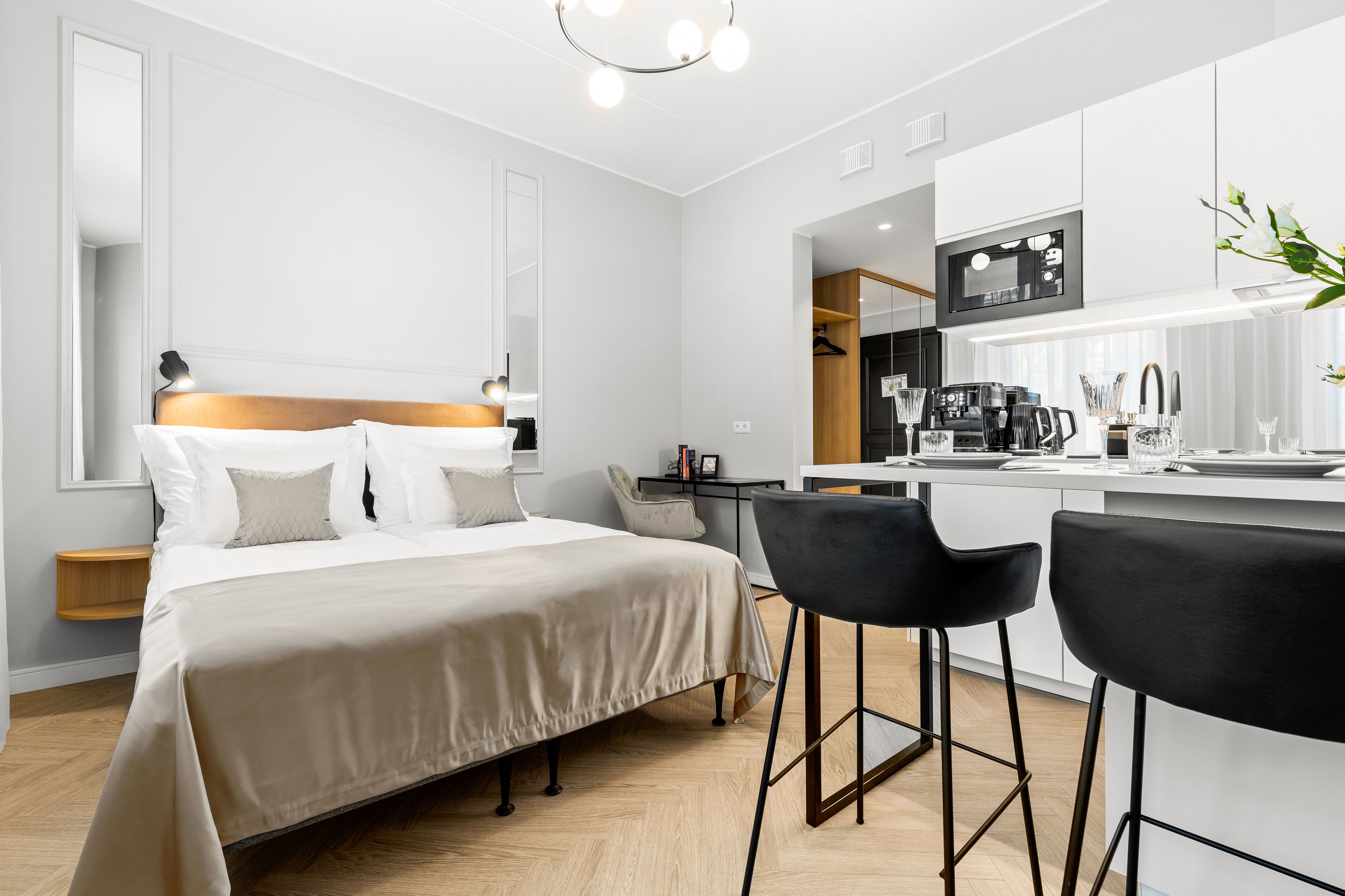 Una habitación de hotel moderna con cama, escritorio y kitchenette.