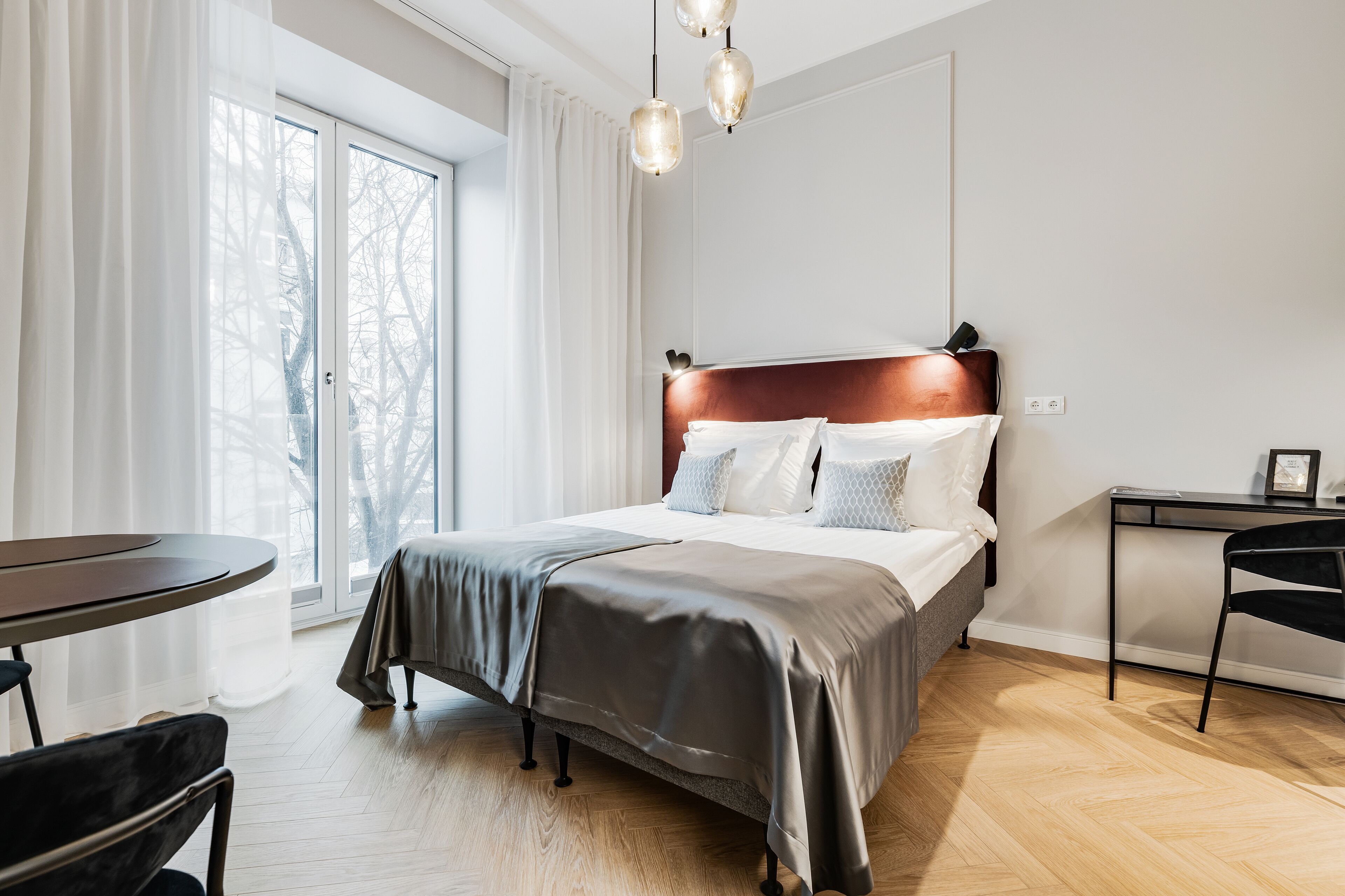 Ett modernt sovrum med en stor säng, ett skrivbord och en stol.