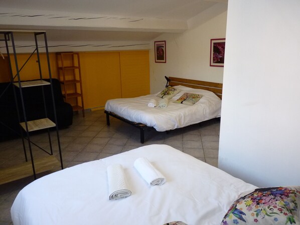 Una habitación de hotel con cama, un escritorio pequeño y una escalera.
