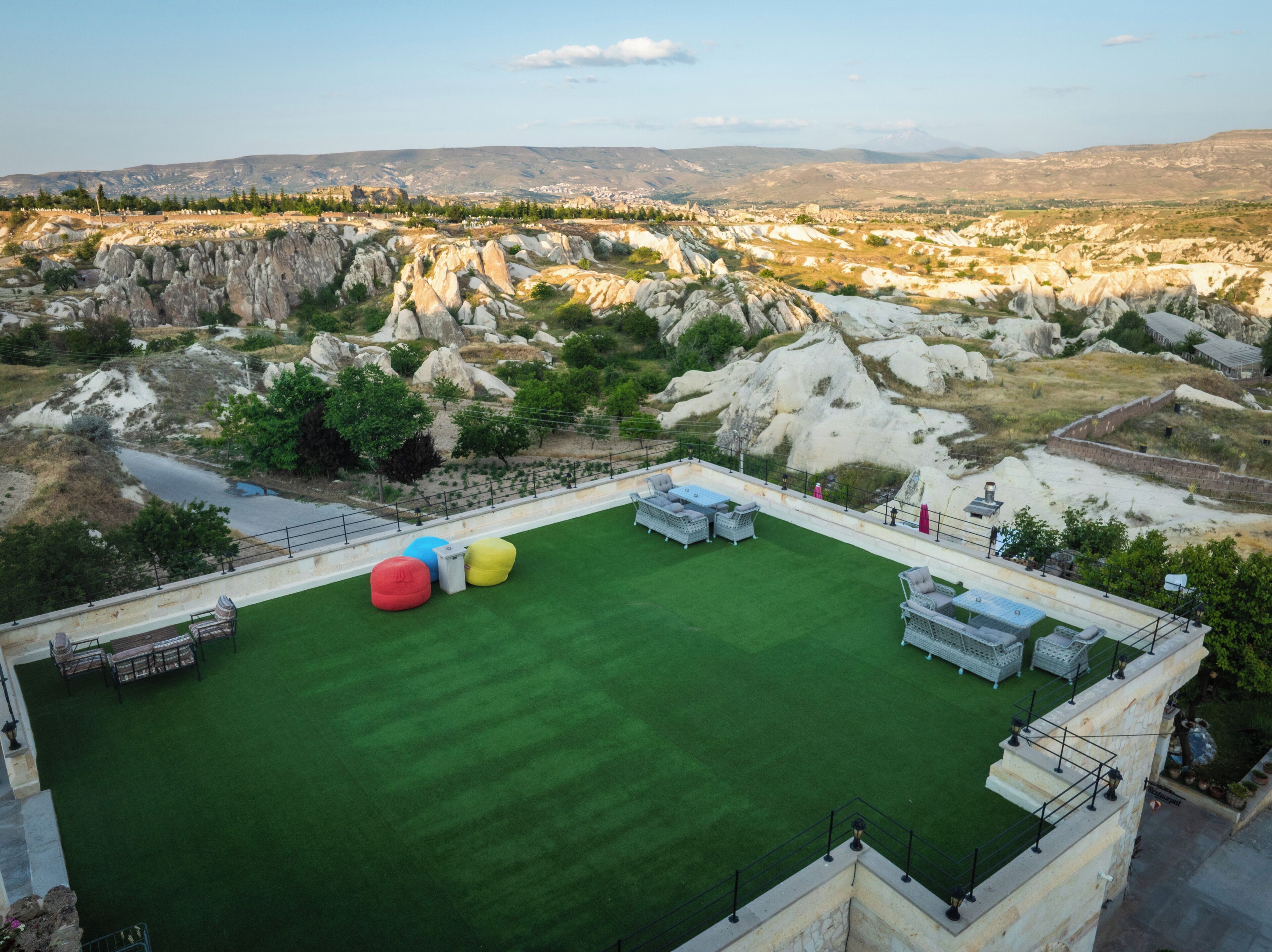 An outdoor area with artificial grass, seating, and a pool.