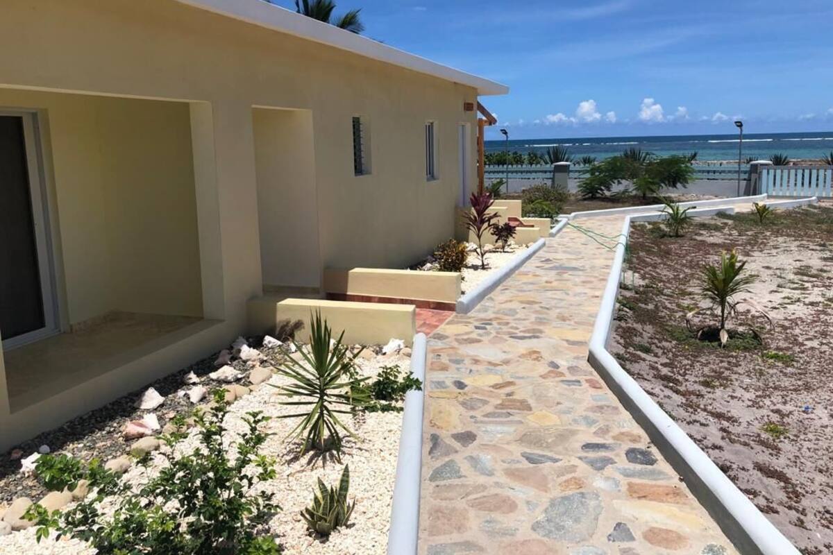 Un edificio moderno con un camino de piedra que conduce a una vista de la playa.