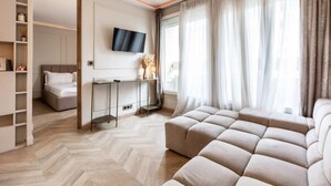A modern hotel room with a large bed, a seating area, a TV mounted on the wall, and a large window with curtains. - Petit Violette I Amazing 1 Bed Apt in Paris (Paris)
