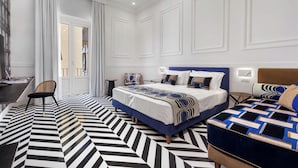 A modern hotel room with a large bed, a desk, and a chair. - Maison Iovino Luxury Rooms (Sorrento)