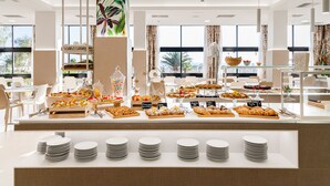 Buffet com diversos alimentos e um balcão com pratos.