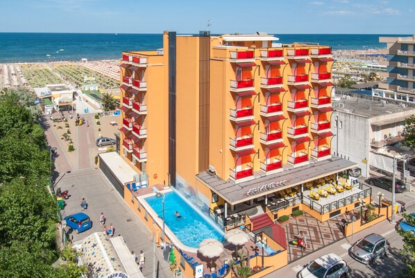 A hotel with a pool, balconies, and a beach view. - Hotel Ariane (Rimini)