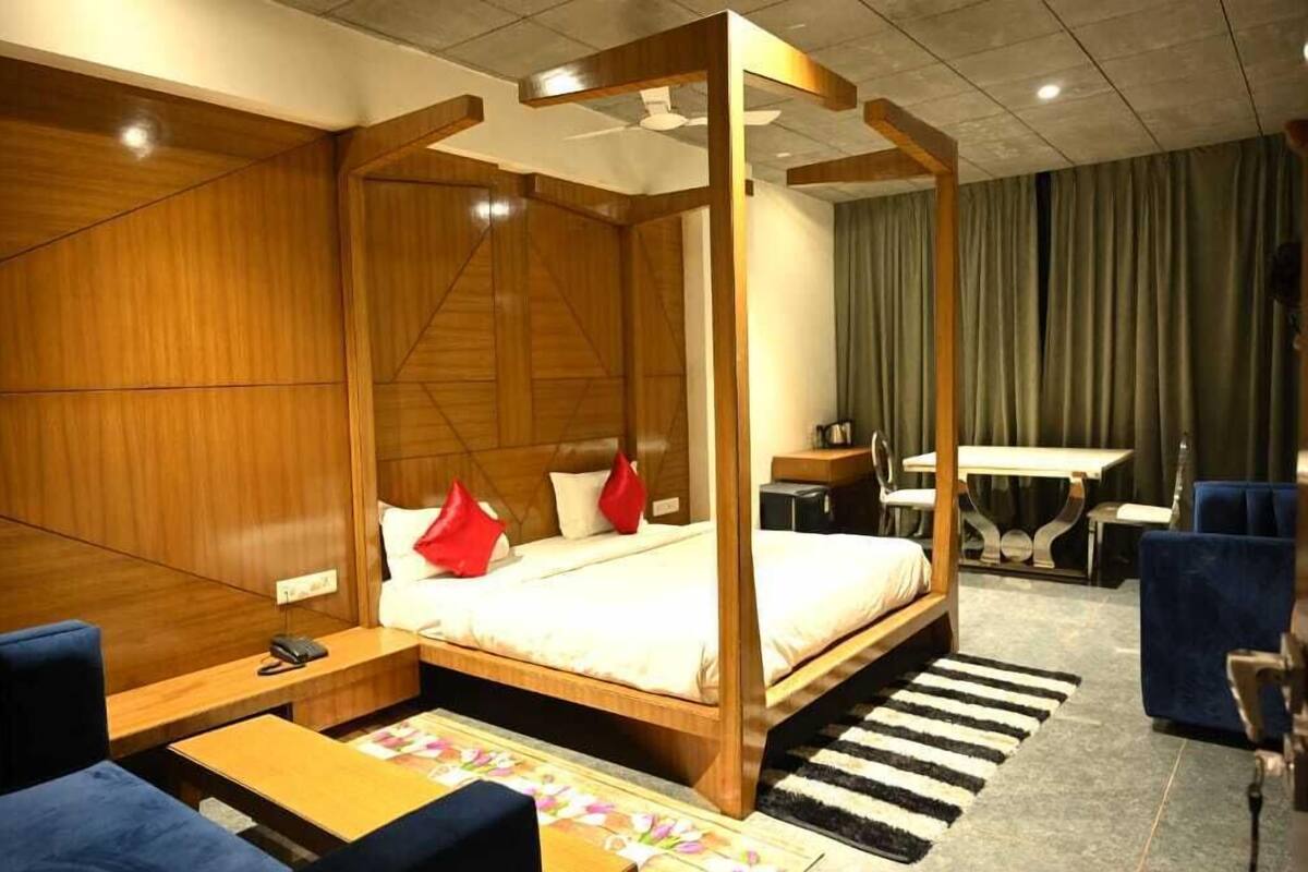 Une chambre avec un lit à baldaquin, un bureau, une chaise et un canapé.