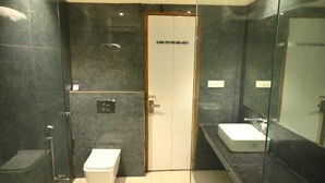 Ein modernes Badezimmer mit Duschkabine aus Glas, Toilette und Waschbecken mit Spiegel.