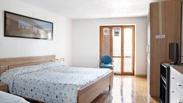 Quarto com cama, cadeira, televisão e guarda-roupa.