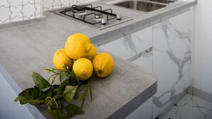 A kitchen with a modern design, featuring a patterned backsplash, a gas stove, and a sink. - Relais Il Sogno di Positano (Positano)
