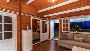 Un interno in legno con un letto, una poltrona e un armadio.