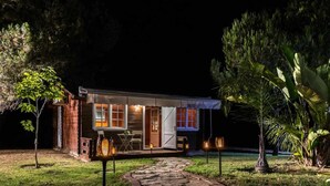 Una piccola casa a un piano con un portico coperto e un vialetto in pietra che conduce all'ingresso.