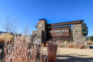A sign for Mammoth Lakes with a stone and wood structure, surrounded by dry grass and shrubs. - Pet-Friendly, Large & Rustic, Gas Grill. Pool, Hot Tub & Tennis Court On-site (Mammoth Lakes)