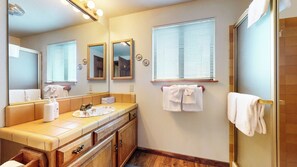 A bathroom with a vanity, mirrors, a towel rack, and a shower area. - Pet-Friendly, Large & Rustic, Gas Grill. Pool, Hot Tub & Tennis Court On-site (Mammoth Lakes)