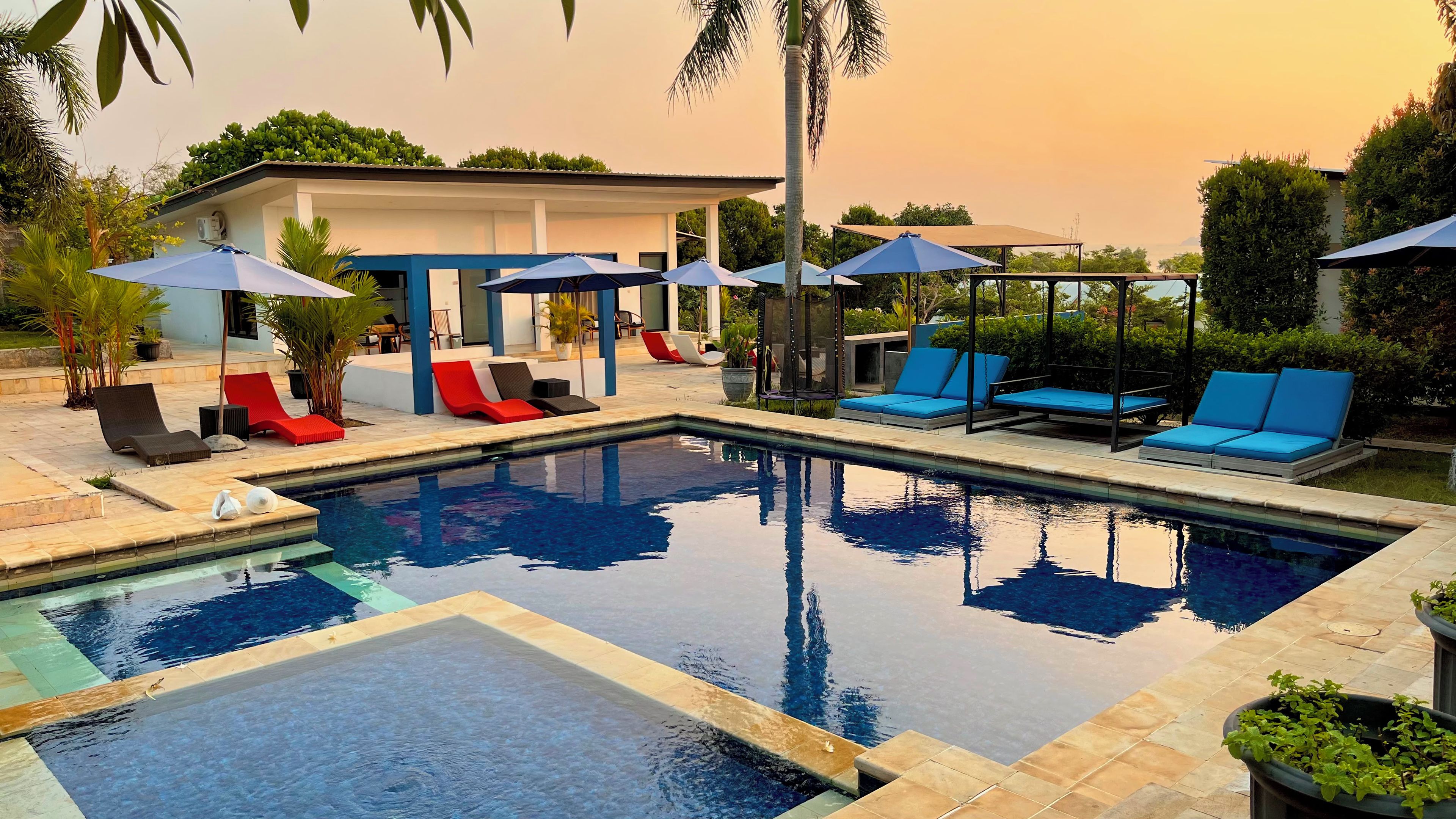 Una piscina al aire libre, sillones reclinables de piscina