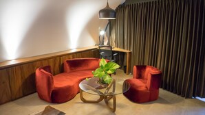 Una sala de estar moderna con un sofá rojo, una mesa de centro de vidrio y una lámpara colgante.