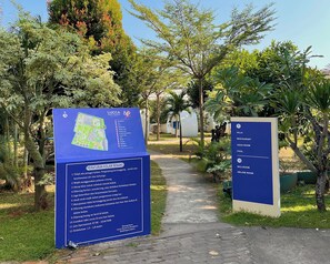 A blue informational sign with a map and a list of amenities at Lucca Resort & Residence. - Lucca Resort & Residence (Bandengan)