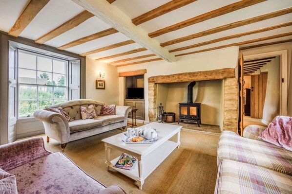 A cozy living room with a fireplace, a sofa, a coffee table, and a television.