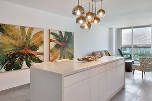 Eine moderne Küche mit einer zentralen Kochinsel, großen Fenstern und Blick auf die Stadt.