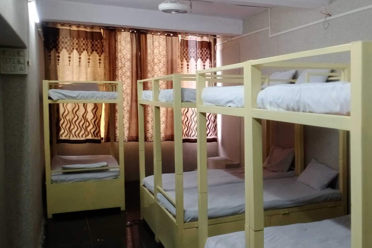 Un dormitorio con literas, una cortina y una lámpara en el techo.