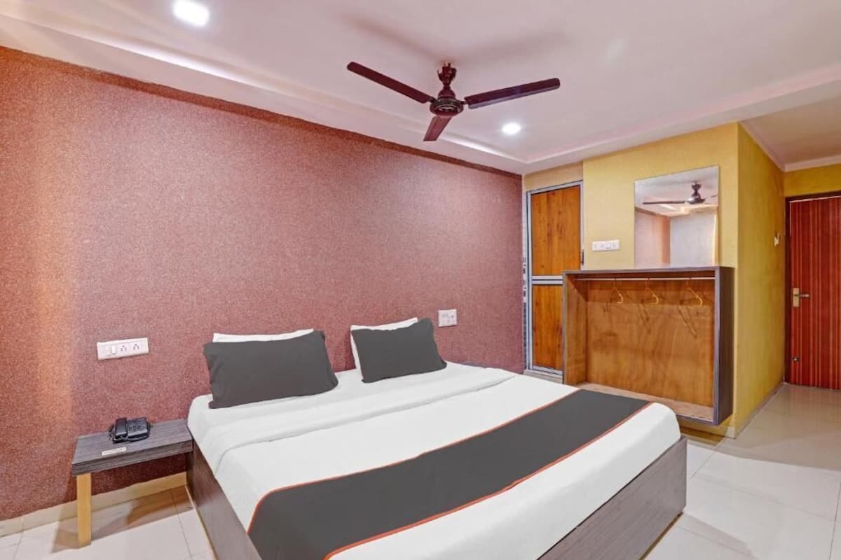 Un dormitorio con cama, mesita de noche, armario y ventilador de techo.