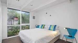 Ein Schlafzimmer mit einem großen Bett, einem Fenster und Blick ins Freie.