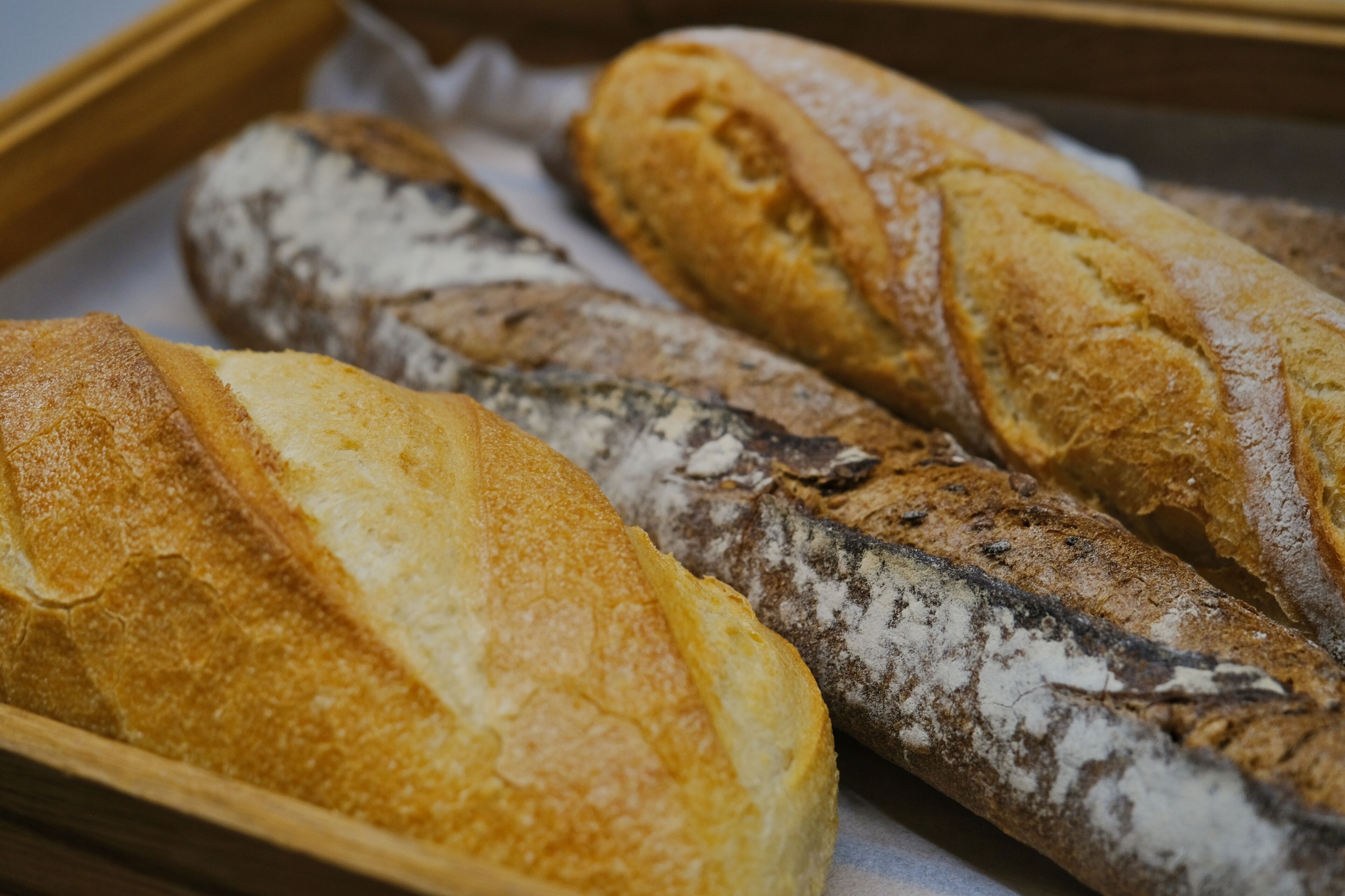 A variety of baguettes in a wooden basket.