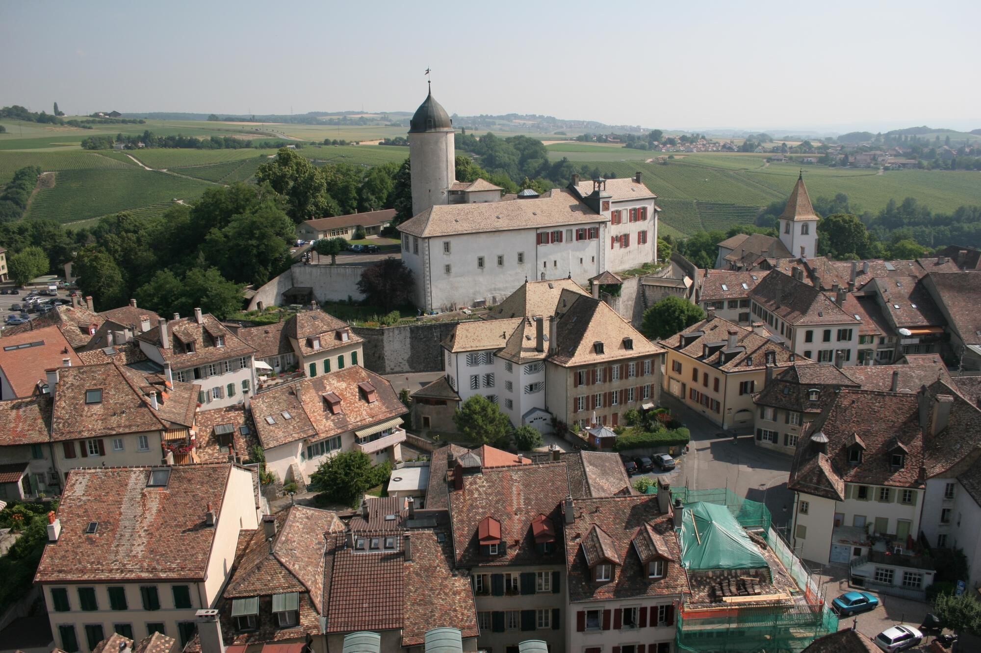 A historic town with traditional architecture, including a prominent tower and a fortified wall.