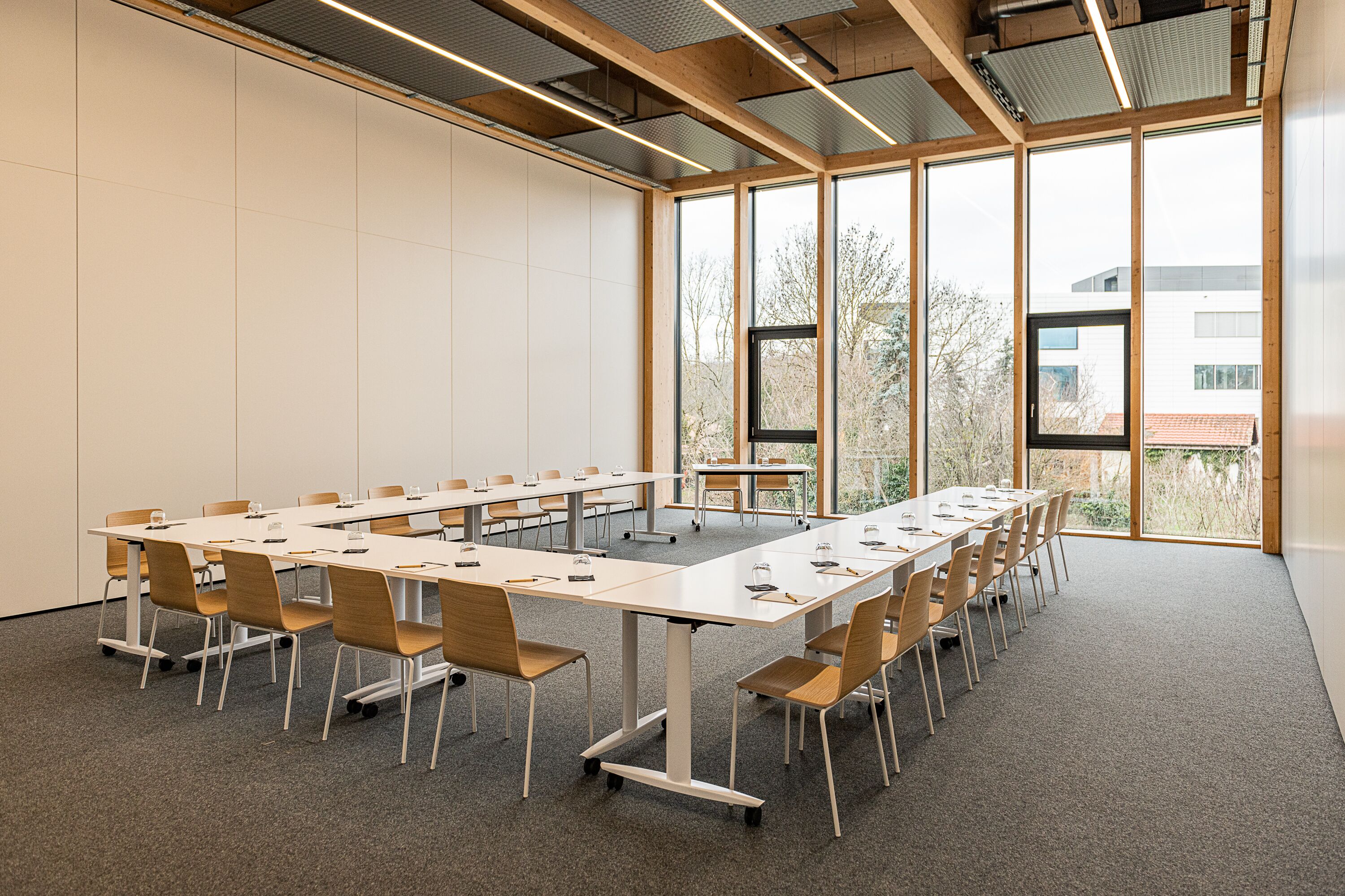 A conference room with a long table, chairs, and large windows.