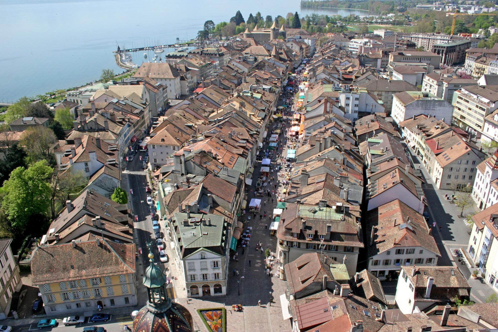 Vista aérea de un pueblo histórico con calles estrechas, arquitectura tradicional y una orilla de agua.