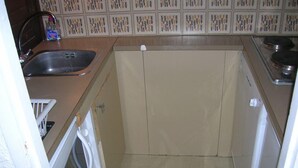 A small kitchen with a sink, a stove, and a microwave. - 10m from ski slopes, 5th floor, view mountain, balcony, tv, ski locker, 28m², Les Menuires (Les Menuires)