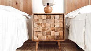 A wooden nightstand with a woven lamp, positioned between two beds with white linens. - Ultimate Ocean View El Cotillo (El Cotillo)
