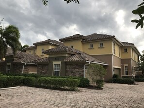 A residential building with a tiled roof, a number '8737' on the facade, and a paved driveway. - Condo in Quarry Resort Community (Naples)