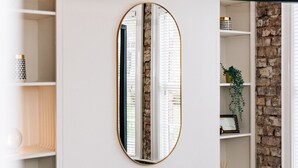 A mirror with a gold frame reflecting a brick wall and white blinds. - STUNNING 5 BEDROOM TOWNHOUSE 5 MINS TO CITY CENTRE (Lisburn)