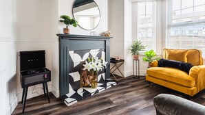 A living room with a fireplace, a yellow sofa, and a black and white patterned wall. - STUNNING 5 BEDROOM TOWNHOUSE 5 MINS TO CITY CENTRE (Lisburn)