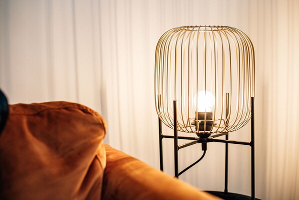 Une lampe moderne au design original, caractérisée par une structure en fil de fer et montée sur un pied.