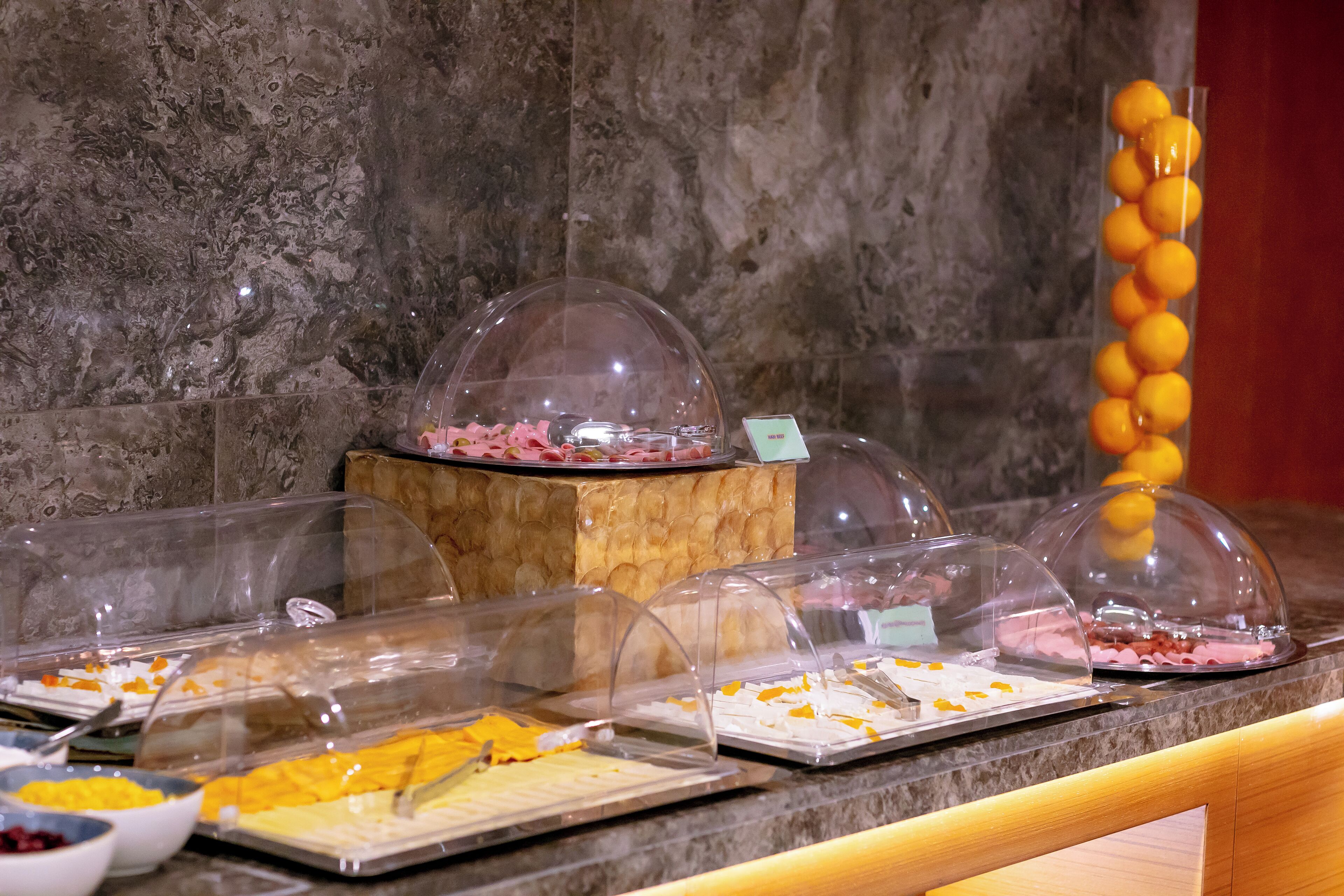 A buffet area with various food items under clear dome covers.