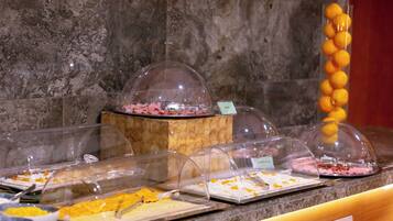 A buffet area with various food items under clear dome covers.