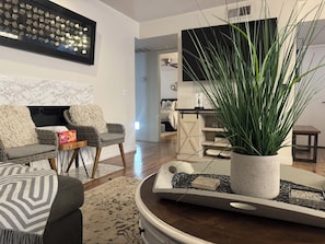 A modern living room with a sofa, chairs, a coffee table, a potted plant, and a TV. - Cozy Home/ASU/Spring Training/Restaurants & More (Tempe)