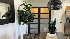 A dining area with a dark wooden table, two chairs, a potted plant, and a hanging light fixture. - Cubs Stadium in backyard/Heated Pool /Dog Friendly (Mesa)