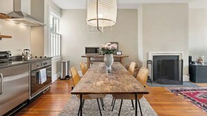 A modern kitchen with a wooden dining table, chairs, and a hanging light fixture. - NO NEED TO LOOK ANY FURTHER! (Washington)