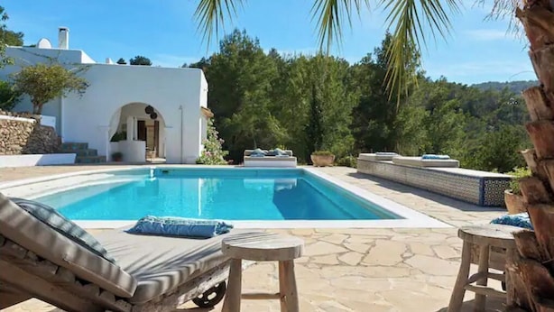 A swimming pool with lounge chairs and a small stool, surrounded by stone tiles and greenery. - LOOK NO FURTHER! Gorgeous old finca with sea view! (Sant Joan de Jabritja)