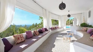 A sunlit interior with a curved seating area, a pool visible through the windows, and a view of the landscape. - LOOK NO FURTHER! Gorgeous old finca with sea view! (Sant Joan de Jabritja)